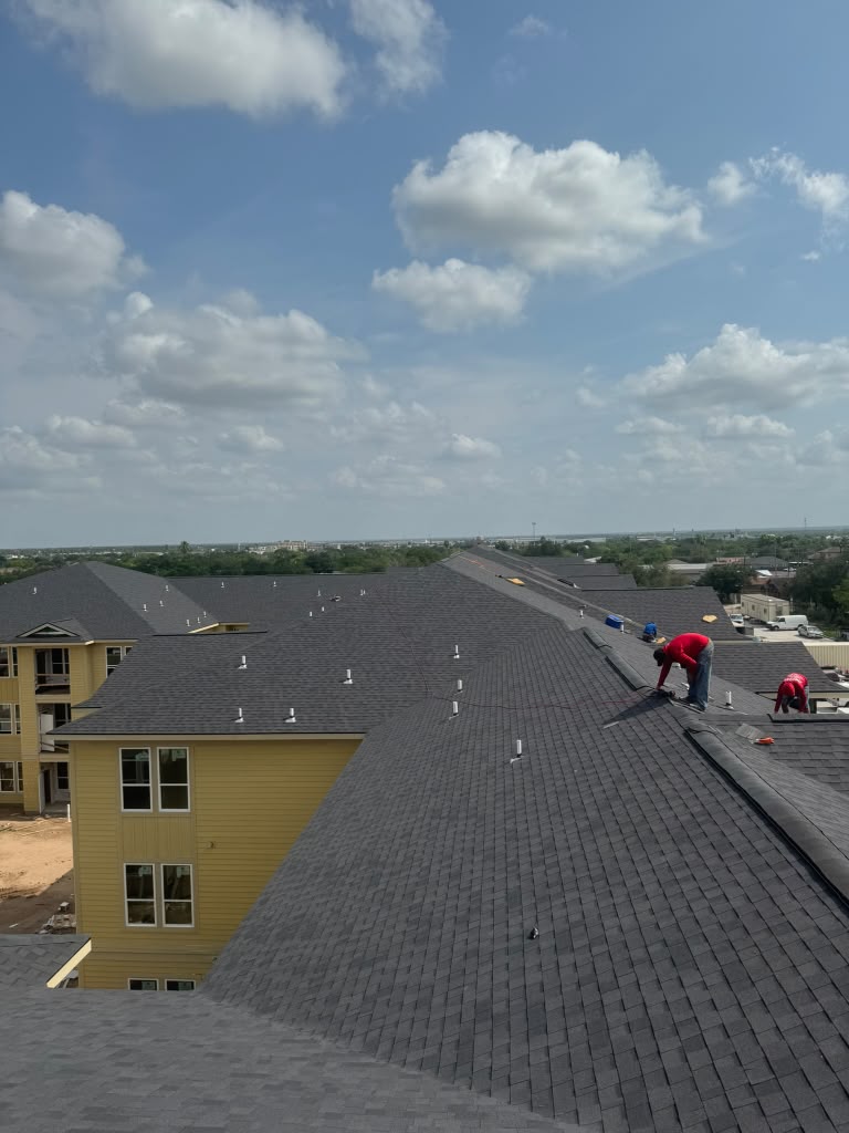 JG Roofing crew installing shingles on an apartment complex roof